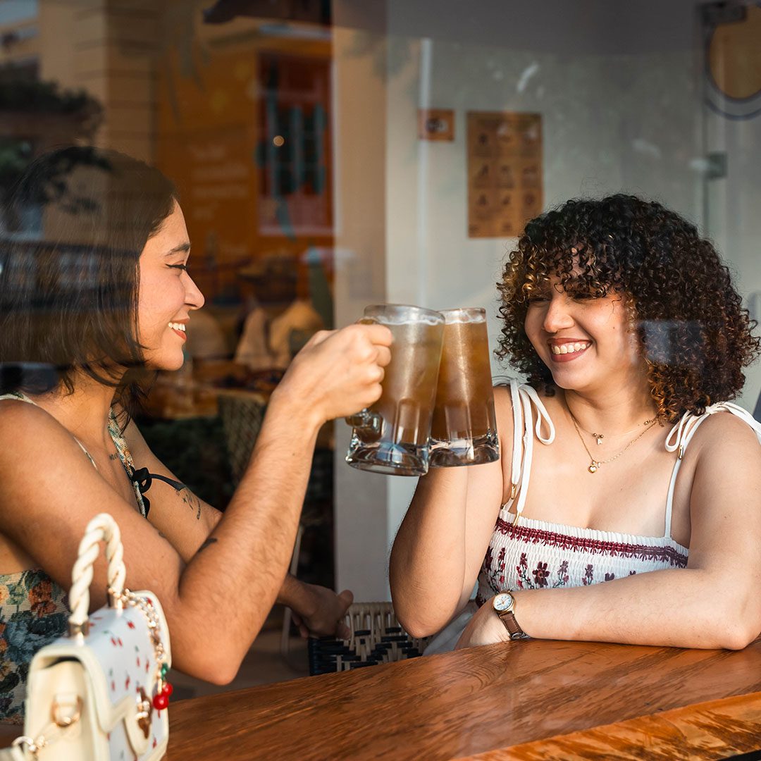 Amigas brindando con cold brew en cafetería Vivolo.